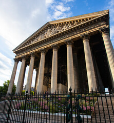 Obraz premium L'église De La Madeleine Paris, France. Lower perspective view from the street with the majestic facade and the Neo-classical columns row.