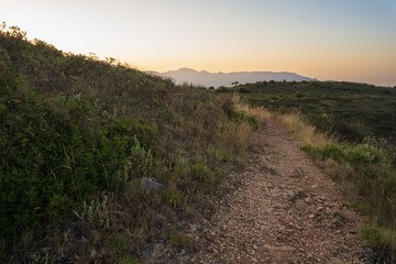 Picturesque mountain trail at sunset in the Alps, Nice, France. Ideal for projects related to travel, nature, recreation, and tourism. >