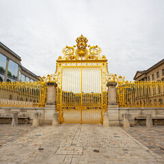 Front gate of the Royal Palace in Versailles. Decorative golden gate at Versailles castle.