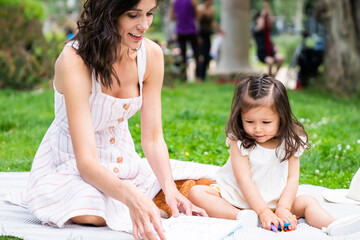 Mother relaxing in park with little daughter