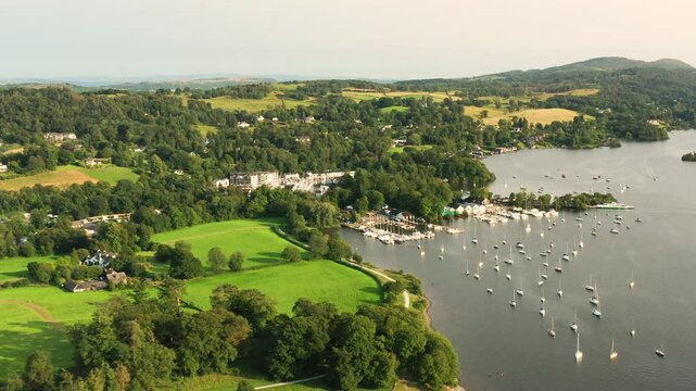 Windermere, Lake District National Park, Cumbria, England. Aerial video fly in to moorings at Windermere Marina Village and Ferry Nab. Summer evening