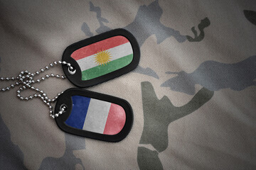 vintage army blank, dog tag with flag of kurdistan and france on the khaki texture background....