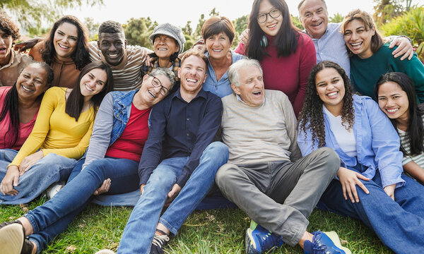Group of multigenerational people smiling in front of camera - Inclusivity and diversity concept - Multiracial friends of different ages having fun together - Main focus on center faces
