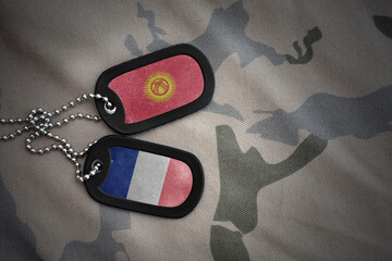 vintage army blank, dog tag with flag of kyrgyzstan and france on the khaki texture background....