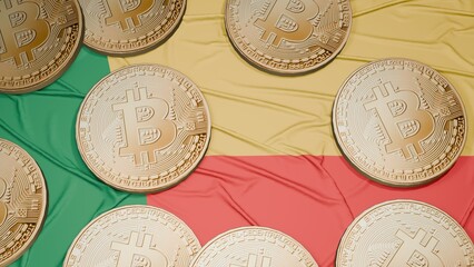 Several bitcoins are laid out on the flag of Benin
