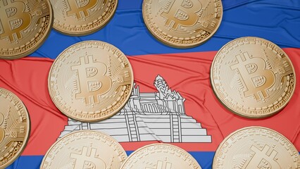 Several bitcoins are laid out on the flag of Cambodia