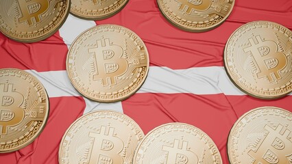 Several bitcoins are laid out on the flag of Denmark