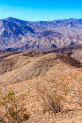 A mountain range with a clear blue sky in the background