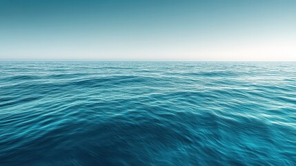 Obraz premium The early morning sunlight casts a soft glow on the calm ocean surface, where gentle ripples dance across the tranquil blue water, creating a serene atmosphere