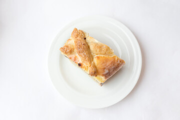 A piece of cottage cheese casserole on a plate pie with poppy seeds on the white background. Syrnik, quark pie. Traditional cake. Ready to eat. Cooking concept