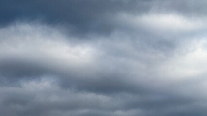 Overcast sky with thick, gray clouds, symbolizing impending rain and melancholy, ideal for illustrating weather-related concepts