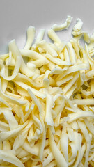 Close-up of fresh shredded mozzarella cheese, perfect for pizza toppings or Italian dishes, emphasizing dairy consumption and culinary creativity