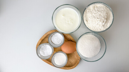 Baking ingredients, including flour, sugar, and an egg, displayed on a countertop, ideal for holiday dessert preparations