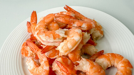 A plate of succulent cooked shrimp, ideal for seafood-themed gatherings or festive holiday feasts like Christmas or Easter