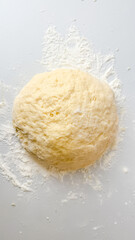 Ball of raw pizza dough on a floured surface, ideal for Italian cuisine concepts and homemade baking projects