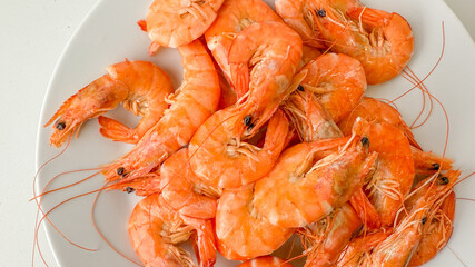 A plate of fresh, cooked shrimp symbolizes a delicious seafood meal, ideal for summer barbecues and festive gatherings