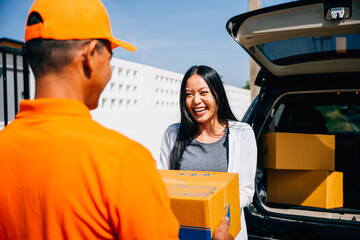 Modern home delivery depicted as a courier in uniform delivers a cardboard parcel to a smiling...