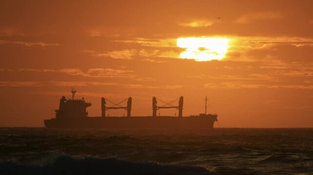 Silueta de barco mercantil en un atardecer