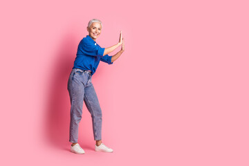 Full length photo of charming positive woman wear blue shirt pulling arm empty space isolated blue color background