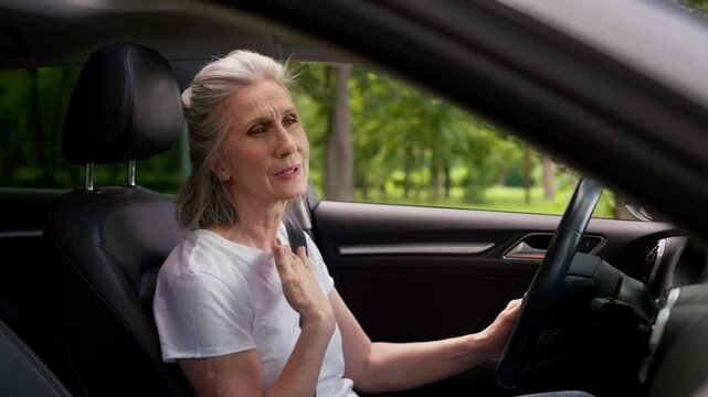 Unhealthy stressed annoyed Caucasian mature senior woman elderly female grandmother automobile driver opening car windows to cool air conditioner suffering heat sweat hot warm weather inside transport