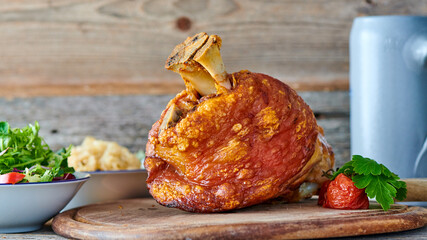 Knusprige Schweinshaxe mit goldbrauner Kruste, serviert mit Sauerkraut auf einem rustikalen Holzbrett.