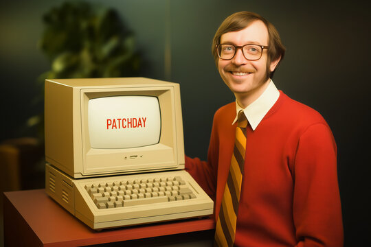 Retro Portrait of Smiling Man with Vintage Computer Displaying Patchday in Classic 1980s Office Setting