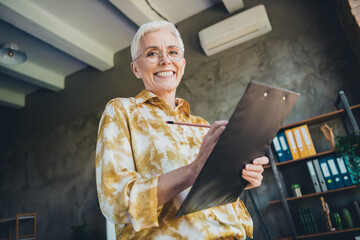 Photo of lovely pensioner lady sign documents dressed yellow print shirt formalwear comfortable...