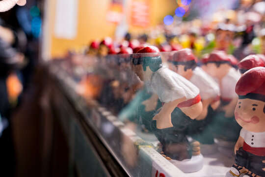 Traditional catalan statues called "caganers" are seen in a stall at a Christmas market at night. Concept of catalan ans spanish culture