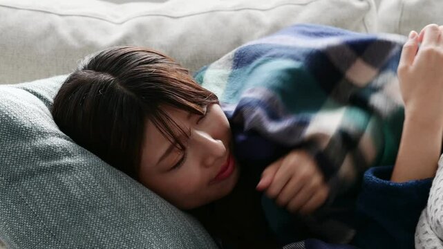 寒気を感じ厚着で寝る日本人女性