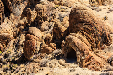 A rocky hillside with a lot of rocks and a small cave
