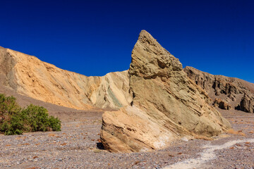 Fototapeta premium A large rock sits in the desert, surrounded by a barren landscape