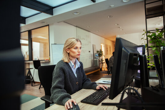 Focused woman working on computer in modern office