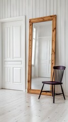 Elegant interior showcasing a tall wooden framed mirror beside a black chair in a bright, minimalistic room with white walls and doors