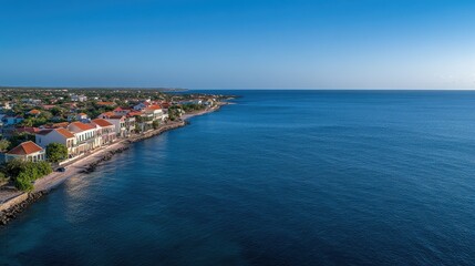 Coastal view of a serene waterfront community at sunset showcasing colorful buildings and the calm ocean horizon