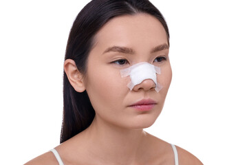 Woman with medical bandage on her nose after plastic surgery operation against white background, closeup