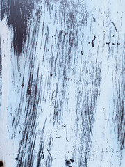 Light blue painted metal surface showing brushstrokes and rust