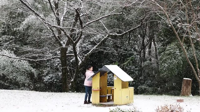 冬の公園で楽しく雪遊びしている小学生の女の子の様子