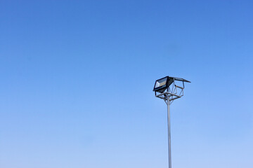 solitary streetlight stands tall against clear blue sky, evoking sense of calm