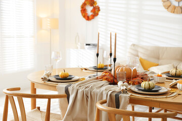 Stylish table setting with beautiful dishware and autumn decor in dining room