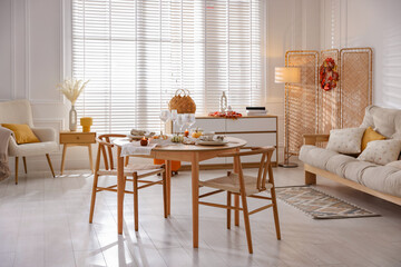 Stylish table setting with beautiful dishware and autumn decor in dining room