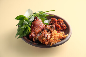 Ayam Penyet with sambal, basil, and crisp, served in a clay pot with a brown background, showcasing Indonesian cuisine