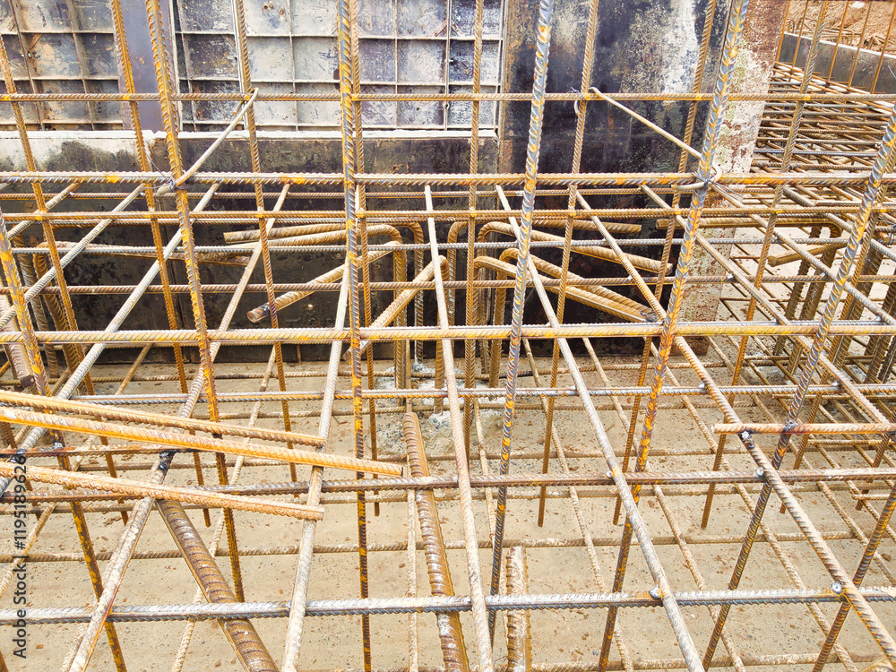 Poster intricate network of rebar and concrete forms the foundation of a modern building under construction