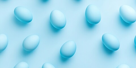 Blue eggs arranged in random positions on a pastel blue backdrop with ample copyspace for minimalist designs and modern concepts focused on spring.