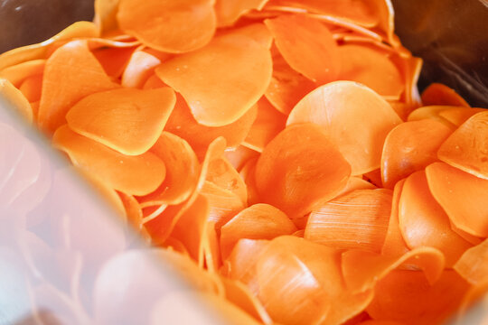 Kerupuk oren mentah or raw orange crackers is a traditional snack from Indonesia. orange crackers on white background