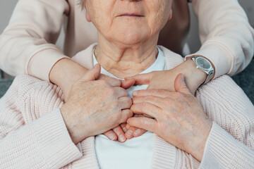 Senior smiling woman feeling young relative's or caregiver supportive touch on her shoulders. Elderly parents, grandparents care and support. Family generations relations concept. Age caregiving.