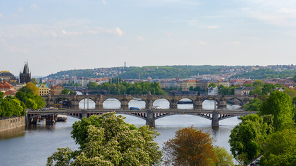 Obraz premium Blick auf Moldaubrücken in Prag mit Altstadt und Hügellandschaft im Hintergrund