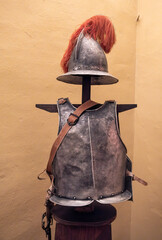 A helmet along with some armor is prominently displayed on a wooden stand