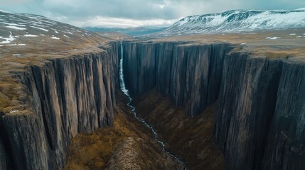Breathtaking Aerial View Reveals a Hidden Valley and Cascading Waterfall Flanked by Majestic Snow-Capped Mountains