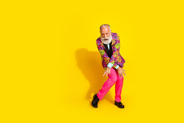 Full size photo of handsome pensioner mister dance knees have fun dressed colorful pink classy garment isolated on yellow color background