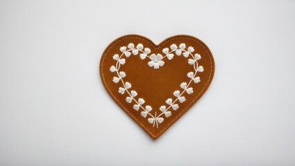 Fototapeta premium Elegant suede patch with stitched edges and floral embroidery.